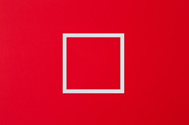 Moldura branca em forma de quadrado sobre fundo vermelho minimalismo flat lay cópia espaço