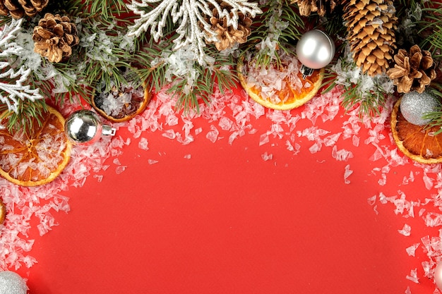 moldura com uma árvore de Natal e decorações coloridas em um fundo vermelho brilhante