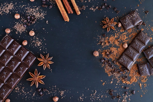 Moldura de barra de chocolate e pedaços com ingredientes de especiarias para cozinhar alimentos doces