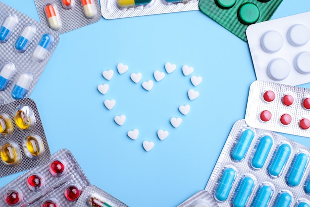 Moldura de coração feita de comprimidos em azul, plana leigos com espaço para texto