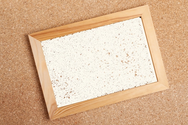 Moldura de madeira com página em branco no quadro de cortiça