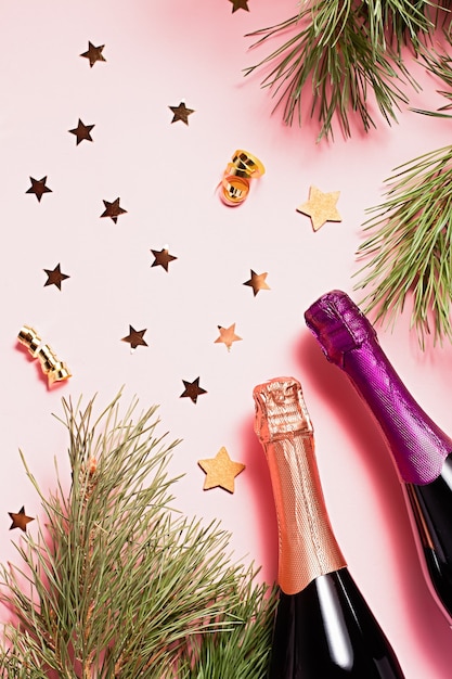 Moldura de natal com pinheiro, sombras, garrafas de champanhe, óculos, máscara de carnaval, enfeites de natal nas cores rosa e roxas. copie o espaço