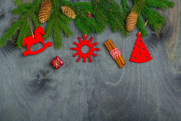 Moldura de Natal de ramos de abeto e decoração de brinquedos artesanais em um fundo escuro de madeira. Natal, férias de inverno, ano novo conceito. Vista superior, plana leigos, cópia espaço para texto