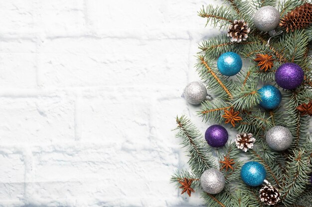 Moldura de Natal feita de abeto, enfeites de árvore de Natal em prata e azul sobre um fundo de tijolo claro. Copie o espaço. Postura plana.