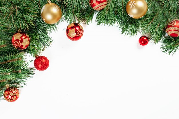 Moldura de Natal, galhos de árvores com ouro e bolas vermelhas isoladas no branco. Isolar.