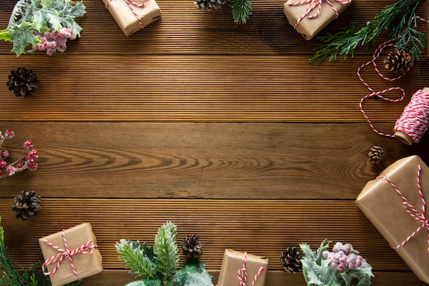 Moldura de natal, mock up, fundo de férias de inverno. caixa de presente de natal com pinhas, brances, na mesa de madeira marrom. natal plana leigos, cópia espaço.