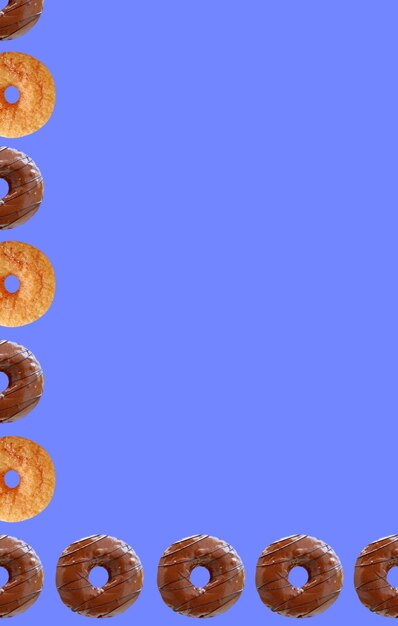 Foto moldura de rosquinhas com cobertura de chocolate e rosquinhas de canela com fundo azul centáurea