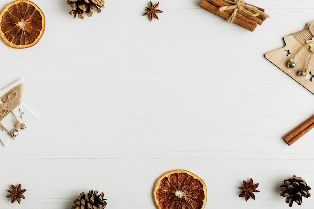 Moldura decorativa, atributos de Natal em uma mesa de madeira branca.