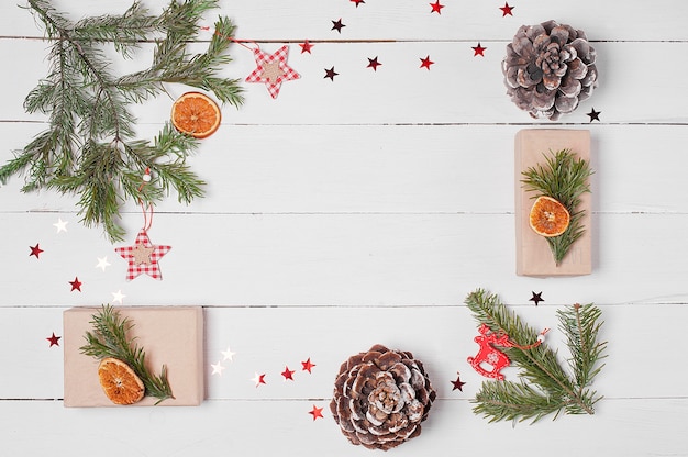 Moldura decorativa de caixas de presente, pinhas, fatias de laranja e galhos de pinheiro