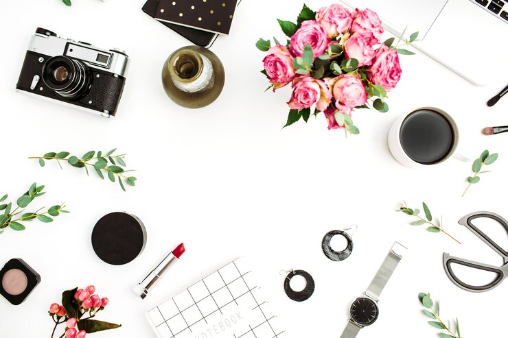 Foto moldura feita de acessórios de moda, cosméticos, flores rosas, câmera fotográfica, caderno em fundo branco. camada plana, vista superior