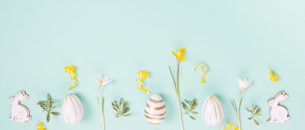 Moldura festiva de borda de páscoa de ovos de páscoa e açafrão de flores de primavera em fundo azul