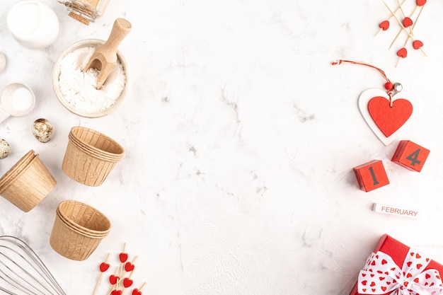 Moldura para assar em casa em um fundo branco. Formas de cupcake de papel. Caixas com fita vermelha para o dia dos namorados. Espaço para copiar.