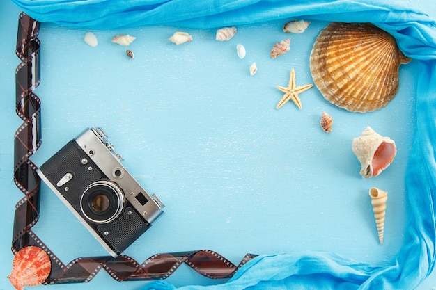 Molduras para fotos de papel em branco com estrelas do mar, conchas e itens na mesa de madeira.