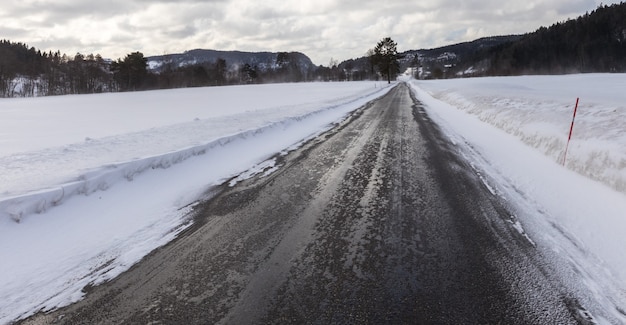 Molhado e escorregadio, uma pequena estrada na Noruega no inverno
