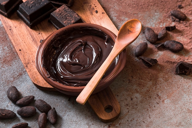 Foto molho de chocolate com pedaços de barra de chocolate e grãos de cacau