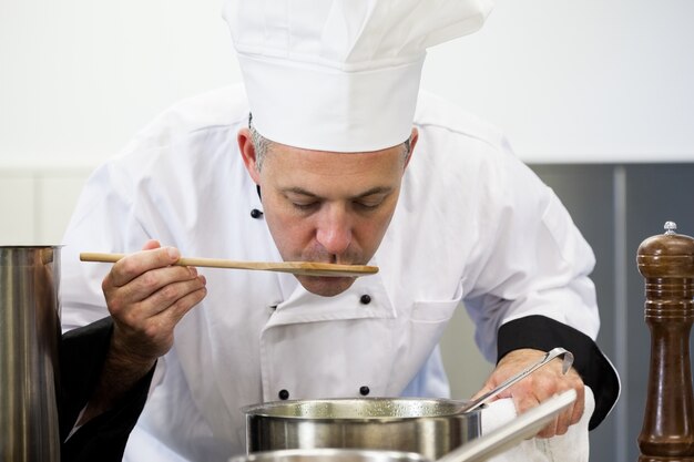 Molho de degustação de cozinheiro chefe focado com colher de pau