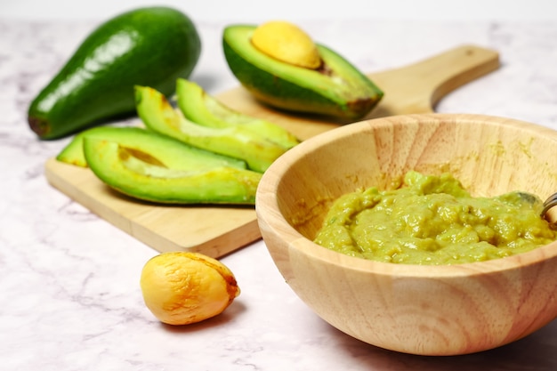 Molho de guacamole com abacate na mesa de mármore