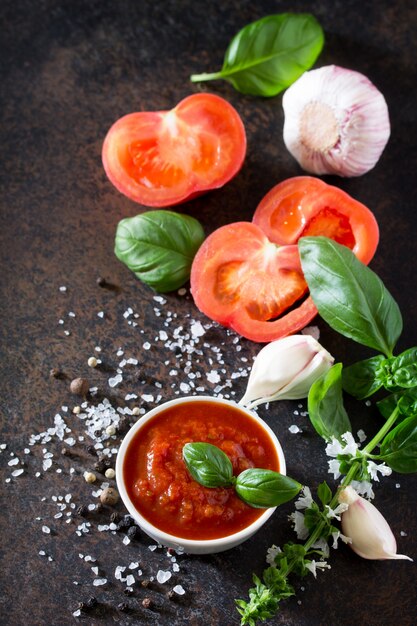 Molho de ketchup de tomate em uma tigela com folhas de manjericão