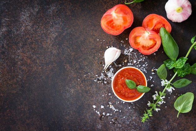 Molho de ketchup de tomate em uma tigela com folhas de manjericão