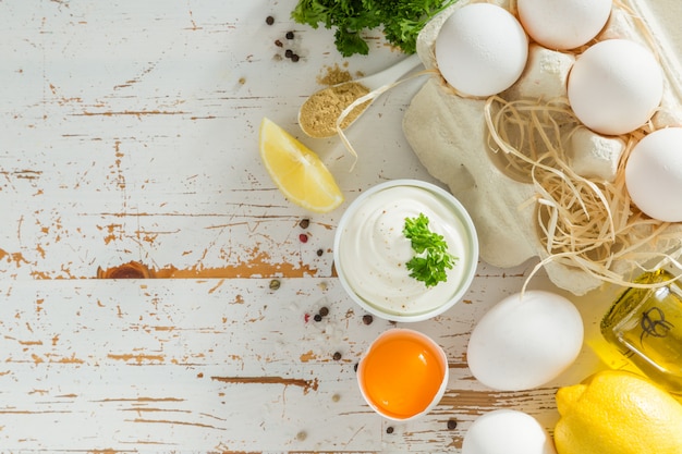 Molho de maionese e ingredientes na mesa de madeira