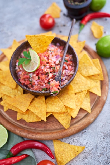 Molho de molho de salsa feito na hora com chips de nacho na placa de madeira