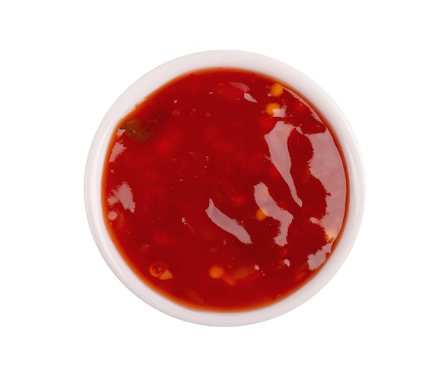 Molho de pimenta doce em uma tigela, isolado no fundo branco. Molho picante de tomate e pimenta. Vista do topo.