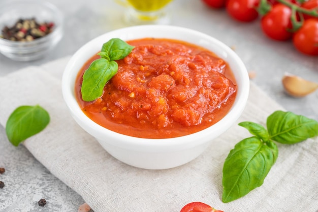 Molho marinara italiano em uma tigela sobre fundo de concreto com especiarias e ingredientes Copiar espaço