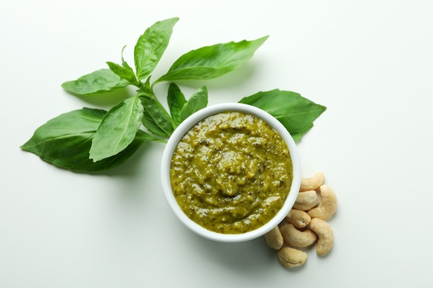 Molho pesto e ingredientes em fundo branco