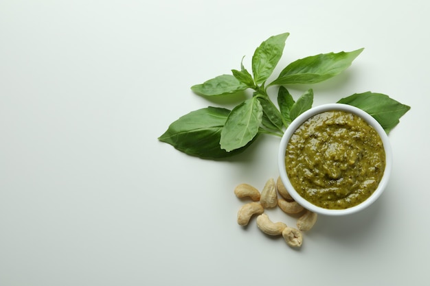 Molho pesto e ingredientes em fundo branco