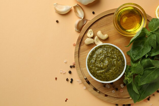 Molho pesto e ingredientes para cozinhar em fundo bege
