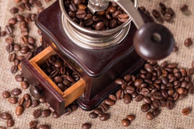 Foto molinillo de café antiguo y granos de café en fondo de tela