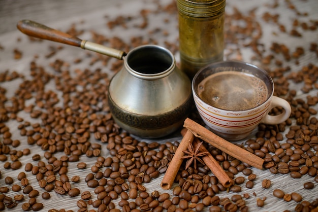 Molinillo de café antiguo con taza, cafetera y frijoles