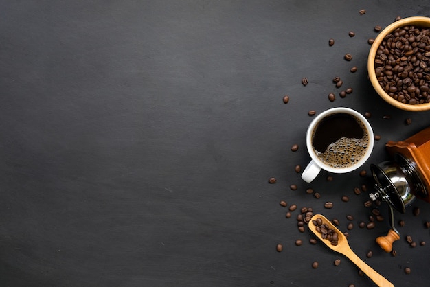 Molinillo de café, frijoles y mano caliente sobre fondo blanco de mesa. espacio para texto. vista superior