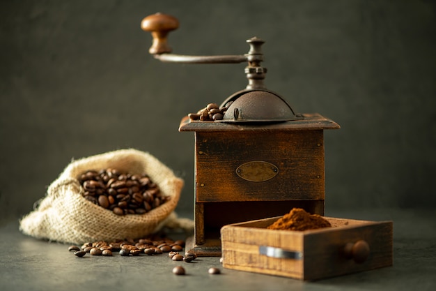 Molinillo de café y frijoles sobre fondo de madera