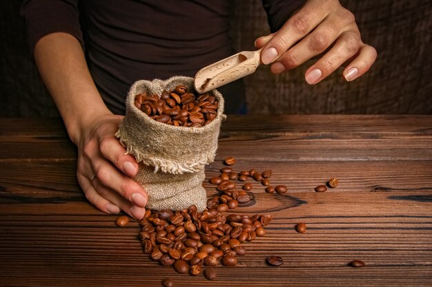 Foto un molinillo de café y manos femeninas.