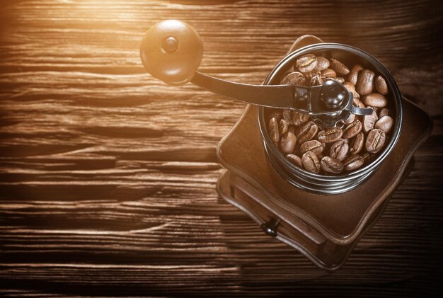 Molino de café granos naturales en tablero de madera vintage