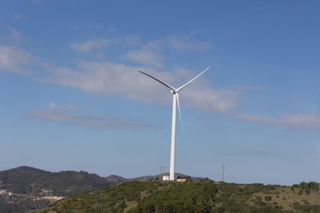 Molino de viento blanco en el fondo de un cielo azul