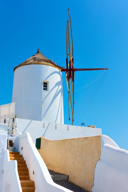 Molino de viento blanco tradicional en la pequeña ciudad de Oia en Santorini, Grecia