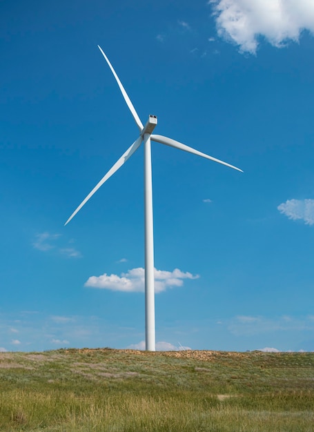 Molino de viento en el fondo del cielo azul nublado Concepto de producción de energía alternativa