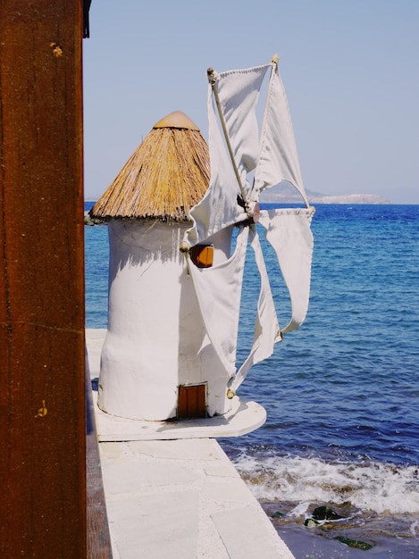 Un molino de viento por el mar contra el cielo