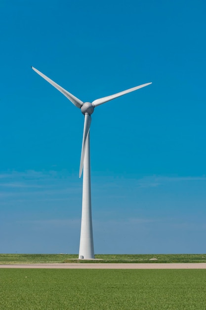 Foto molino de viento en tierra contra un cielo azul claro