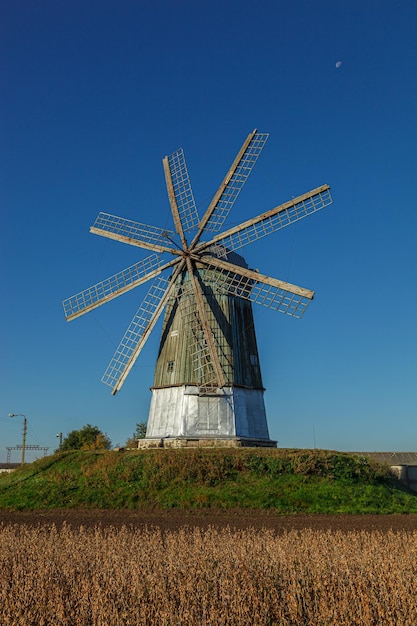 Molino de viento tipo holandés contra el cielo azul de cerca