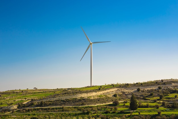 Molinos de viento durante el brillante día de verano. prado verde con turbinas de viento que generan electricidad.