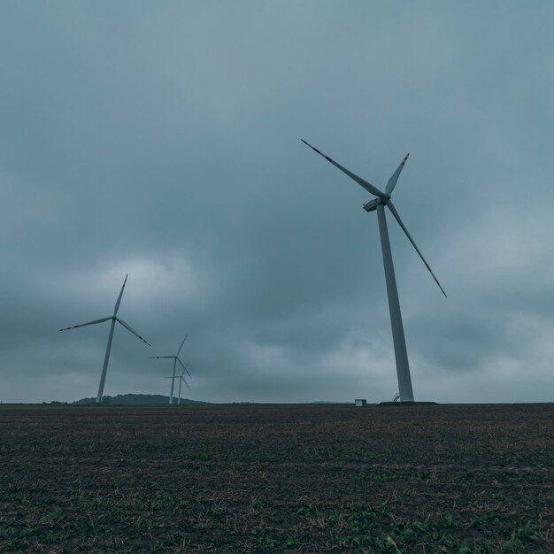 Molinos de viento en el campo con cielo nublado en el fondo