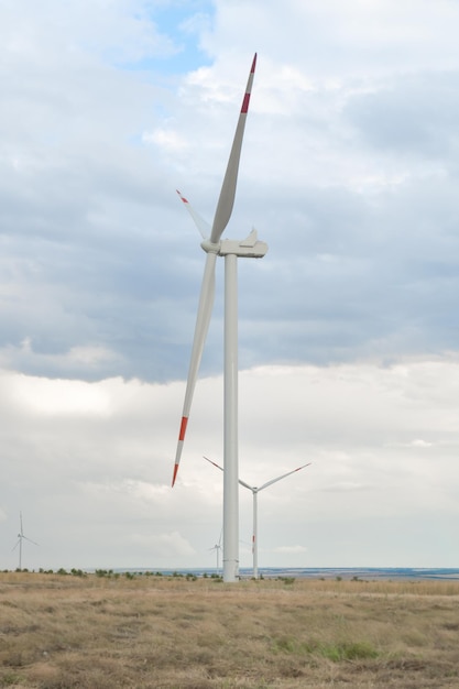 Molinos de viento para la generación de electricidad. Clima nublado de la turbina de viento