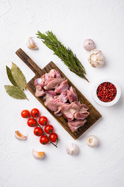 Mollejas de menudillos de pollo de pájaro fresco, estómagos, sobre fondo de mesa de piedra blanca, vista superior plana, con espacio de copia para texto