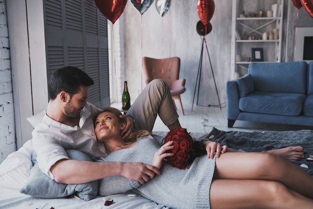 Momente der Freude. Schönes junges Paar umarmt beim Liegen auf dem Bett zu Hause