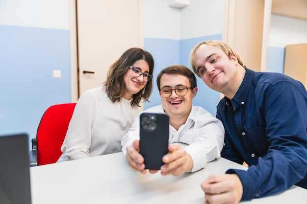 En un momento de alegría, los compañeros de trabajo de uno con síndrome de Down se toman una selfie.