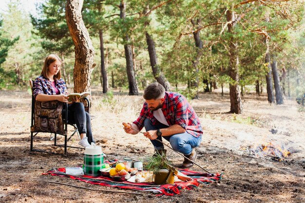 Momento de casal enquanto acampar e preparar comida