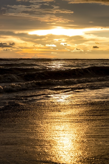 Foto momento de la hora dorada del atardecer en la playa del mar con luz solar reflejada